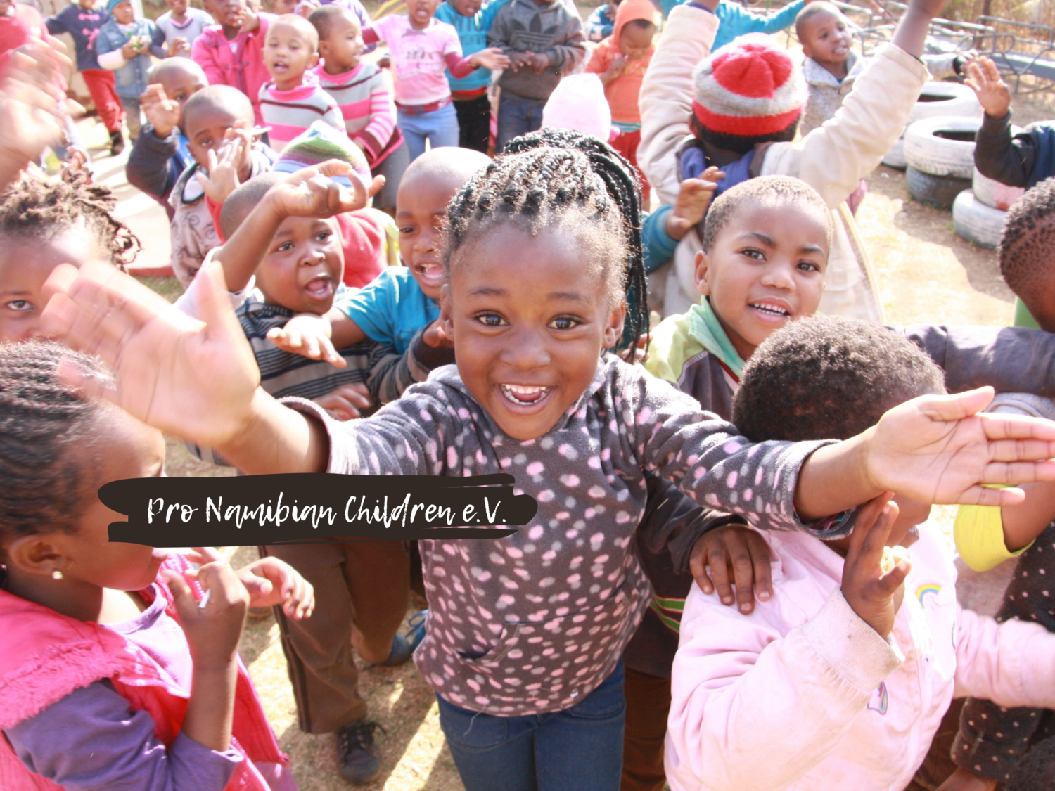 spielende Kinder mit Banner pro Namibian children e.V.