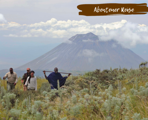 Menschen auf Wanderung zum Kilimandscharo mit Beschriftung ,,Abenteuer Reise"